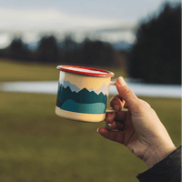 Emailletasse Becher von Roadtyping, ideal für drinnen und draußen, zeigt das stilvolle Design auf der weißen Tasse.