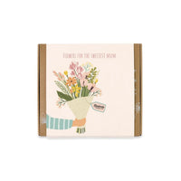 Blossombs Geschenk-Box Mittel für drinnen und draußen, mit bunten Blumen und Gartenaccessoires, in dekorativer Verpackung.