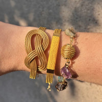 Armreif Graviola am Handgelenk, kombiniert mit weiteren Armbändern aus Goldgras