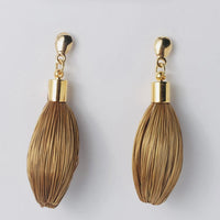 Goldene Ohrringe Buriti von Capido, elegantes Accessoire mit filigranen Details, sichtbar im Bild.