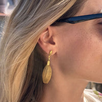 Goldene Ohrringe Buriti von Capido, elegantes Accessoire mit detailreicher Gestaltung, sichtbar in der Nahaufnahme.