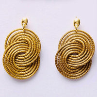 Goldene Tainha Ohrringe von Capido, elegante Accessoires mit filigranem Design, sichtbar an den Ohren getragen