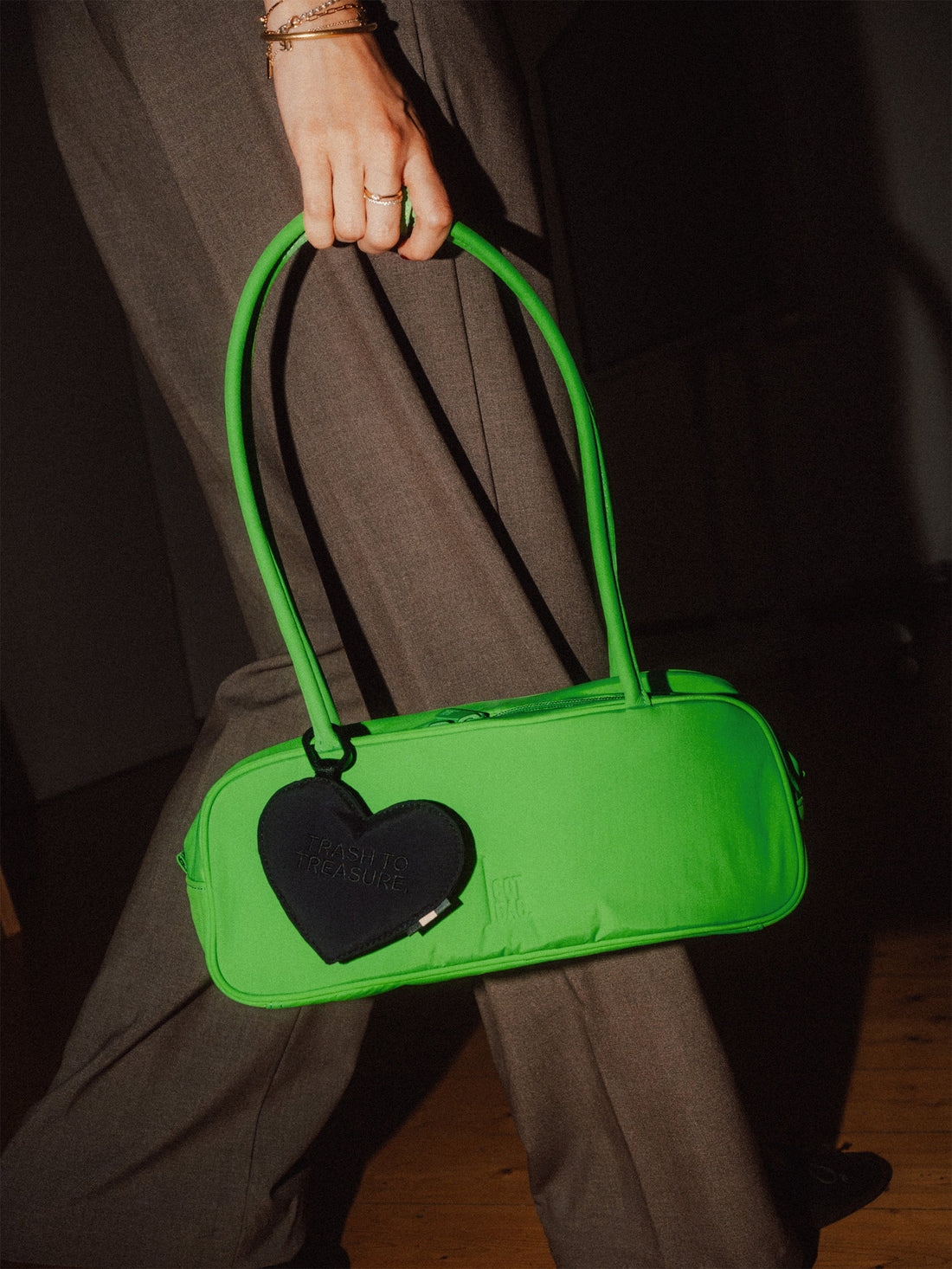 Treasure Charm von Got Bag in black, herzförmiger Anhänger in der Hand gehalten