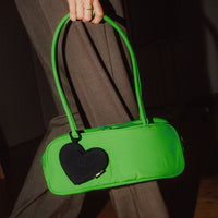 Treasure Charm von Got Bag in black, herzförmiger Anhänger in der Hand gehalten