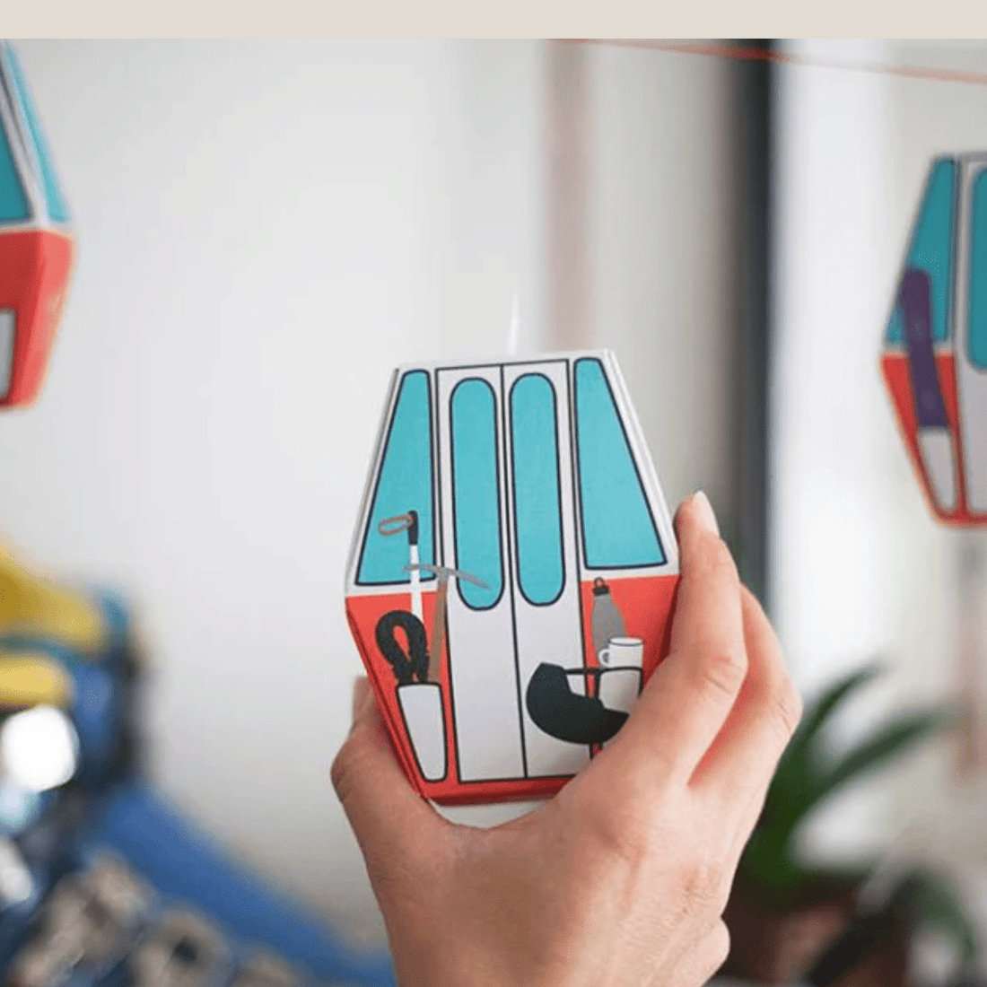 Hand hält eine einzelne Papp-Gondel aus dem Roadtyping Adventskalender