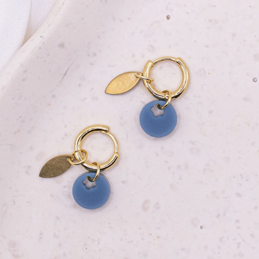 Goldene Creolen-Ohrringe von tilda & theo, elegantes Accessoire mit glatter Oberfläche und runden Form, zum Tragen in den Ohren.
