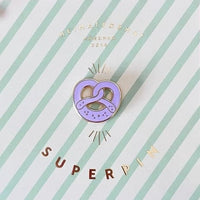Haltbarer Pin Breze von Heimatformat, kleines Accessoire mit detailreicher Design in verschiedenen Farben, auf hellem Hintergrund.