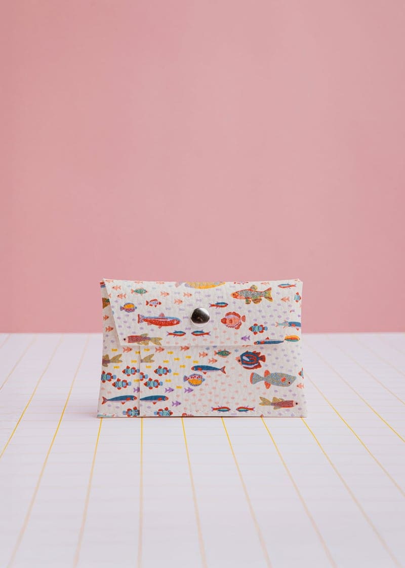 Geldbeutel mit Druckknopf und bunten Motiven von Ecke, aus Leder, mit Platz für Karten und Bargeld, auf einem weißen Hintergrund.