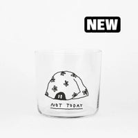 Ein 350ml Glas mit Spruch von yahya studio, transparent mit schwarzem Aufdruck, auf weißem Hintergrund.
