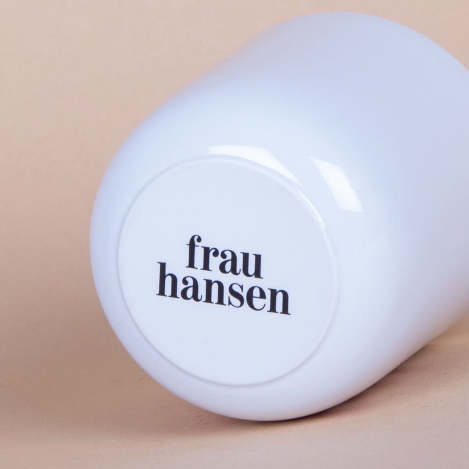 Franzbrötchen Becher von Frau Hansen, mit einem frischen Franzbrötchen auf einem Teller, detailreiche Nahaufnahme, Essen & Trinken