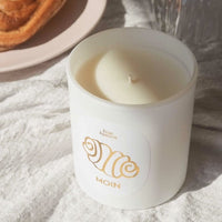 Duftkerze "Franzbrötchen" von Frau Hansen, brennend, mit warmem Licht, geeignet für drinnen und draußen, aromatischer Duft