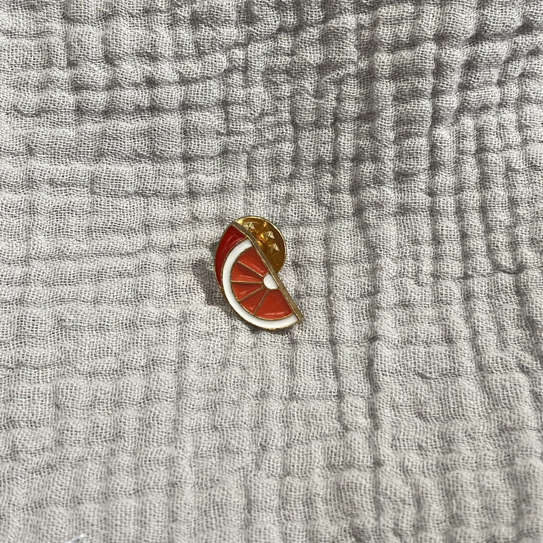 Oranger Pin von Donaustern, Herz & Hand Accessoire, detailreiche Schmucknadel mit Herzmotiv, auf weißem Hintergrund.
