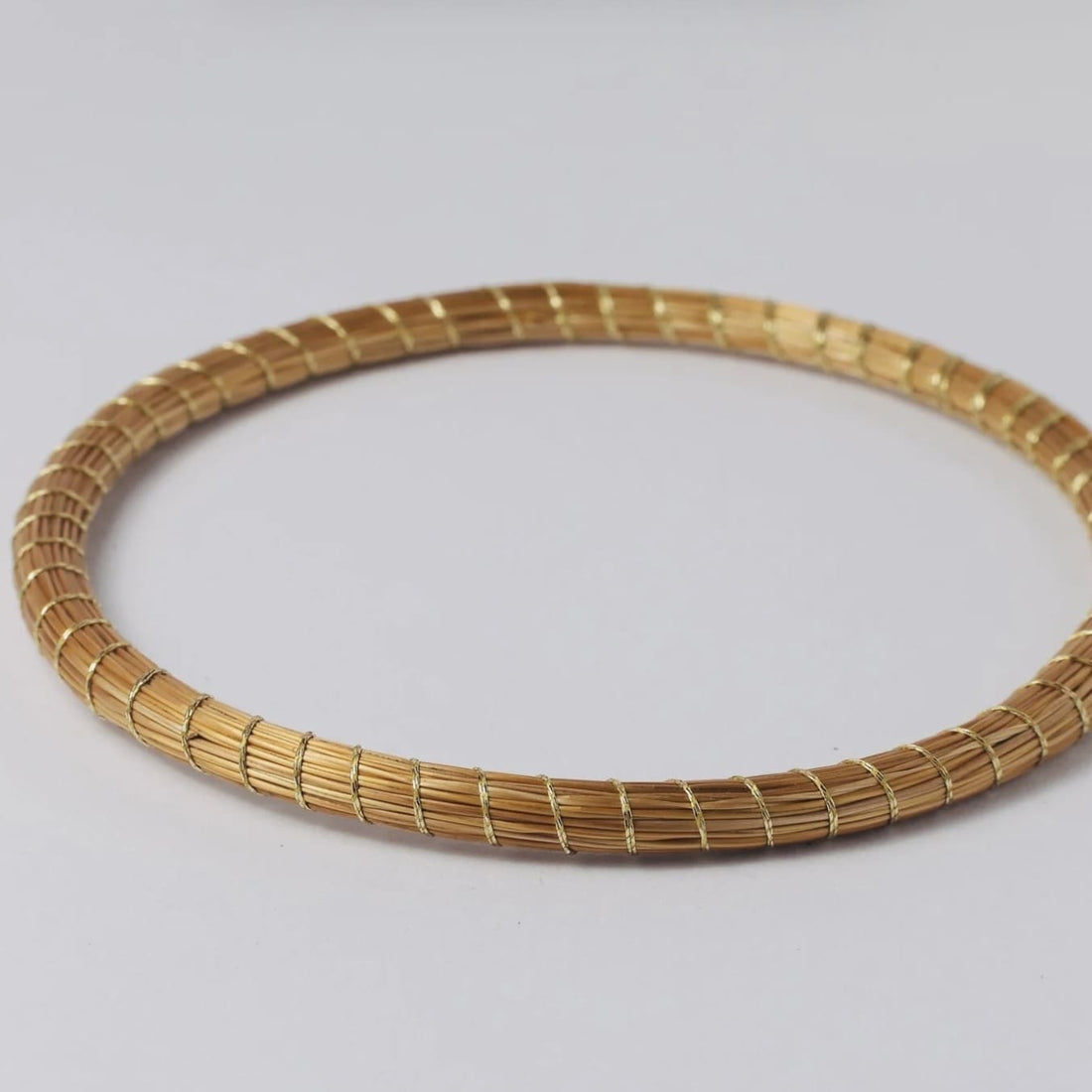 Armreif Amarilis von Capido, elegantes Schmuckaccessoire mit filigranen Details, auf einem weißen Hintergrund fotografiert.