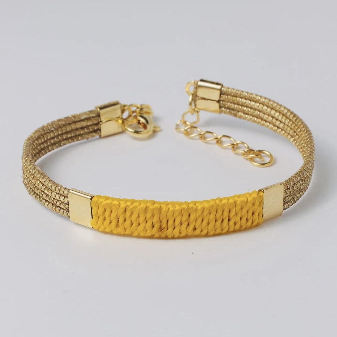 Armreif Grilo I Capido aus Accessoires, detailreiche goldene Schmuckschließe, elegantes Design, sichtbar auf dem Bild.