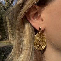 Goldene Ohrringe Tainha von Capido, elegantes Accessoire mit filigranen Details, sichtbar auf dem Bild