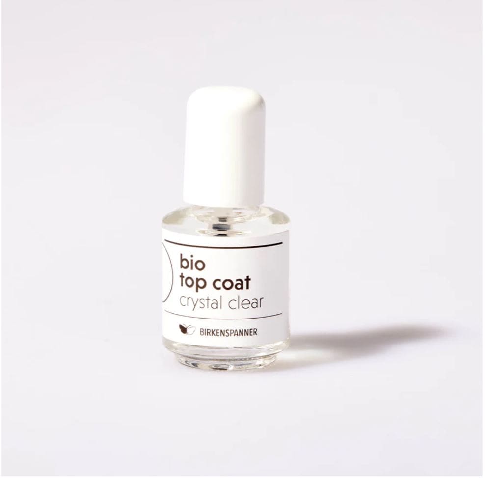 Transparenter Bio Top Coat "Crystal Clear" von Birkenspanner, glänzender Nagellack für gepflegte Nägel, auf einer weißen Oberfläche.